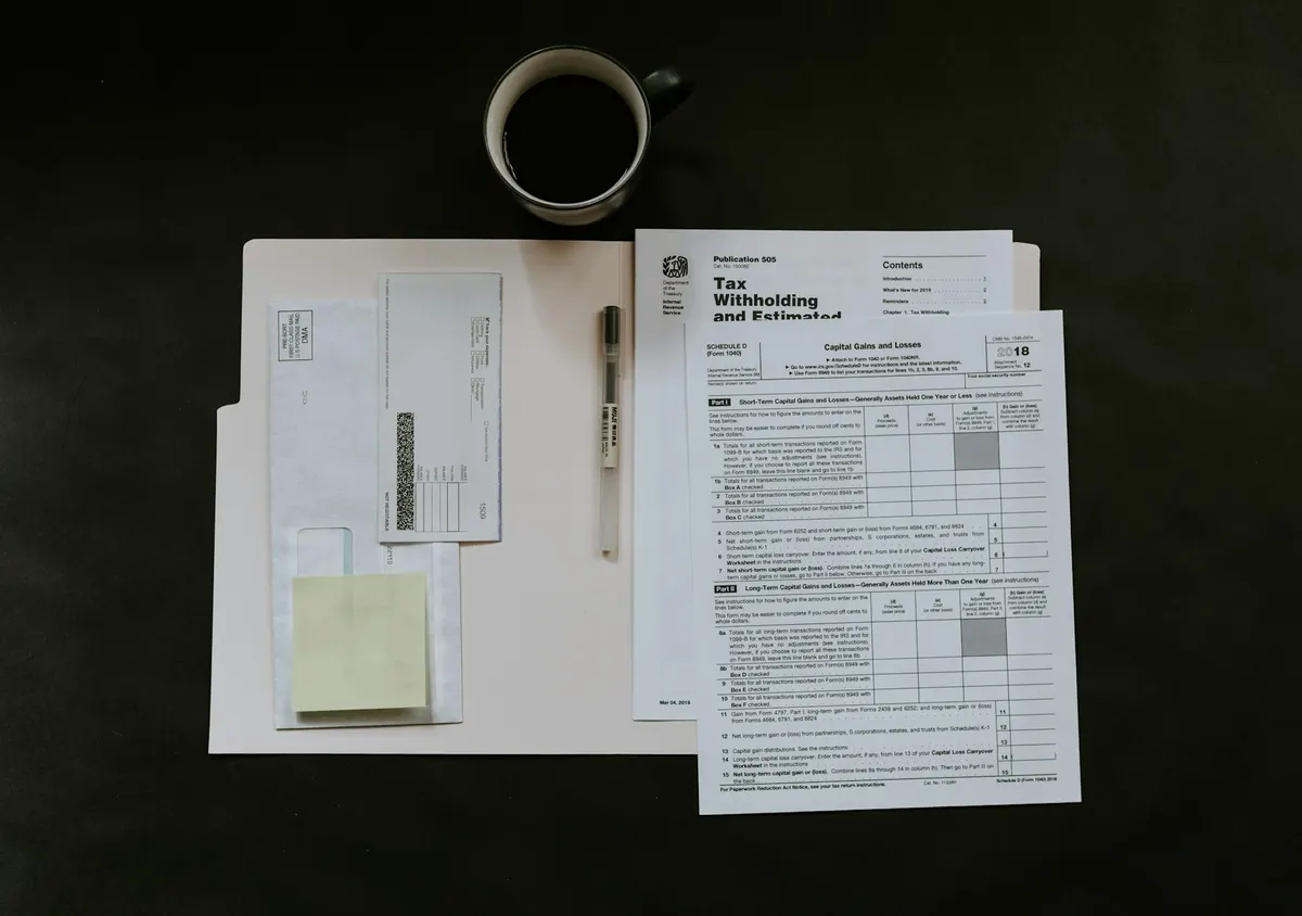 Printed forms and a pen on a dark desk