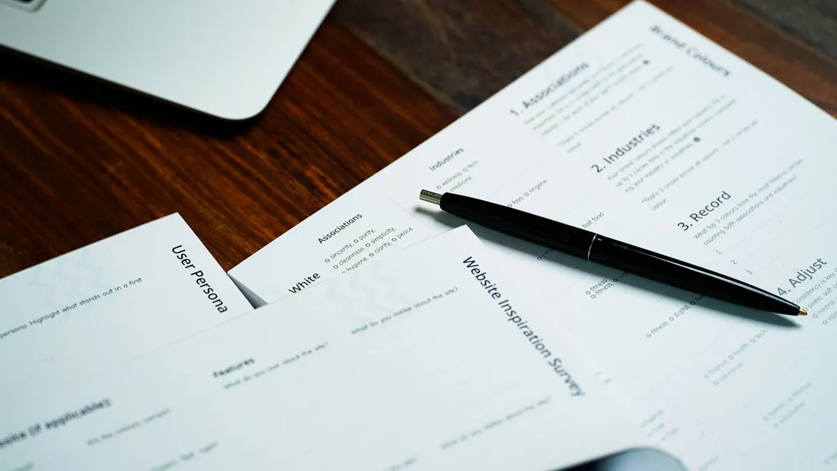A pen resting on printed documents